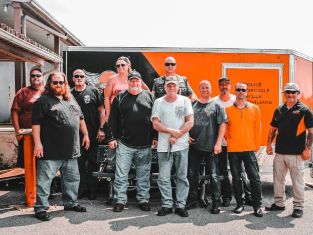 A ProRider class standing together in front of the training trailer at the end of the day