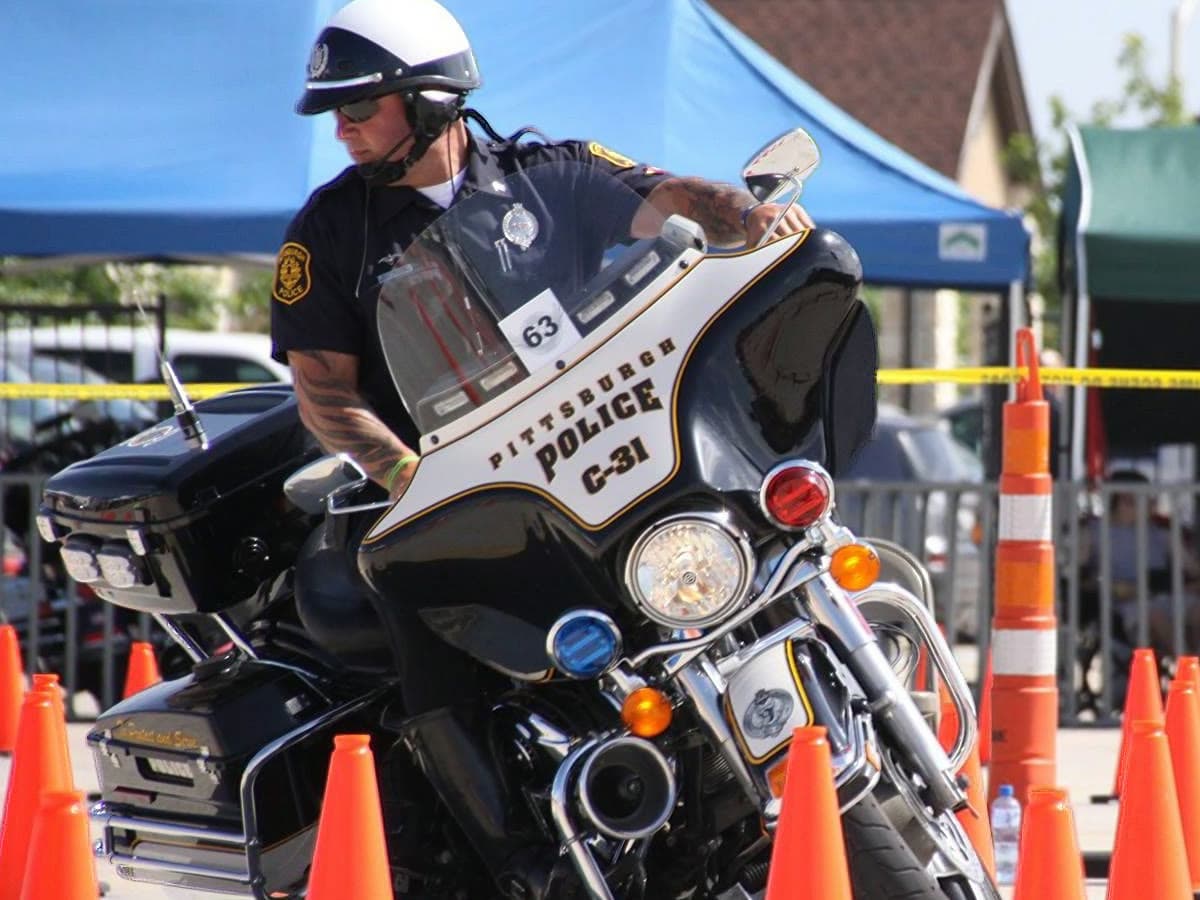 A single rider close in, leaned into a slow turn on a police motorcycle